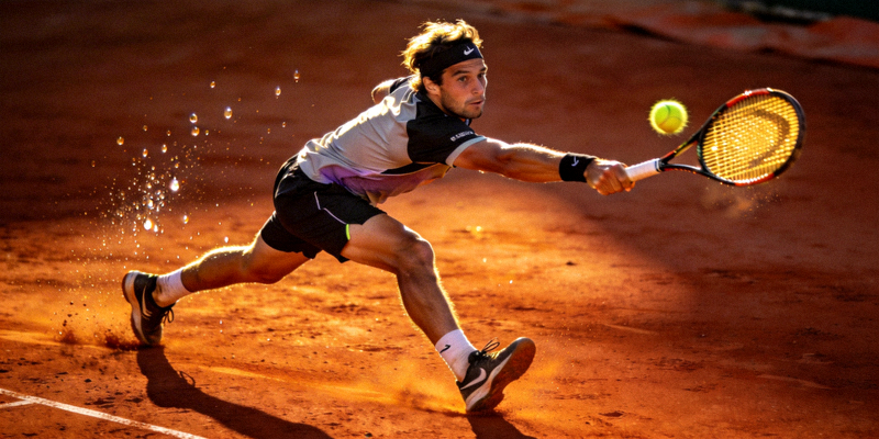 网球运动员在红土场上奋力击球的专业动作